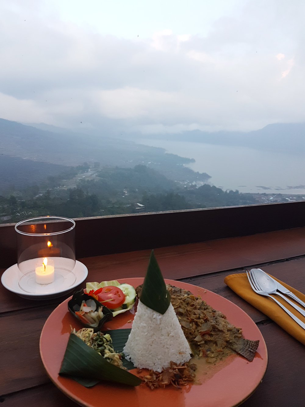 Plate of Balinese food and view of Lake Batur at Lakeview restaurant